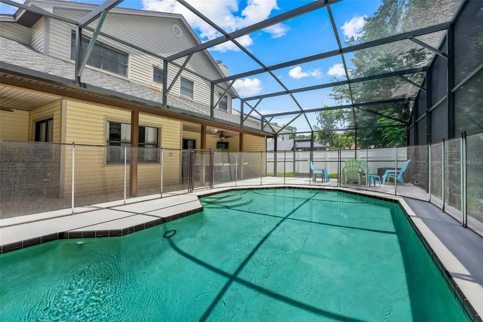Screened in pool surrounded by a child safety fence
