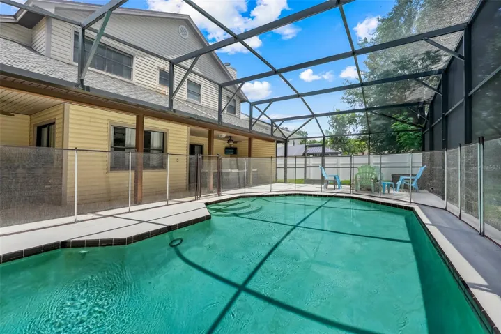 Screened in pool surrounded by a child safety fence