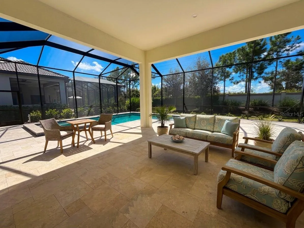 A screened pool and spa combination set against a travertine deck!