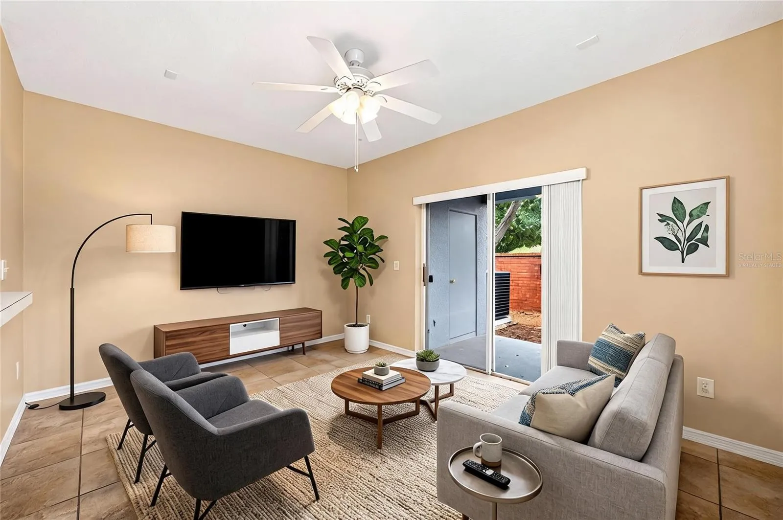 Sliding glass doors open up to a covered lanai. Family room virtually staged.