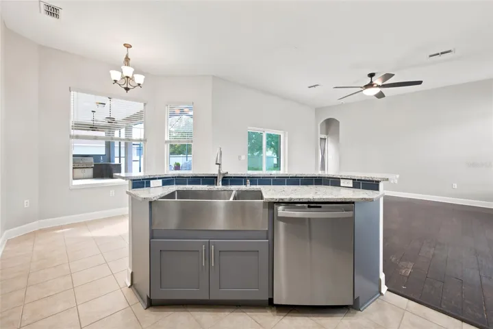 Remodedled Kitchen with Quartz Countertops with Island and Sunken Sink over looking Family Room and Pool