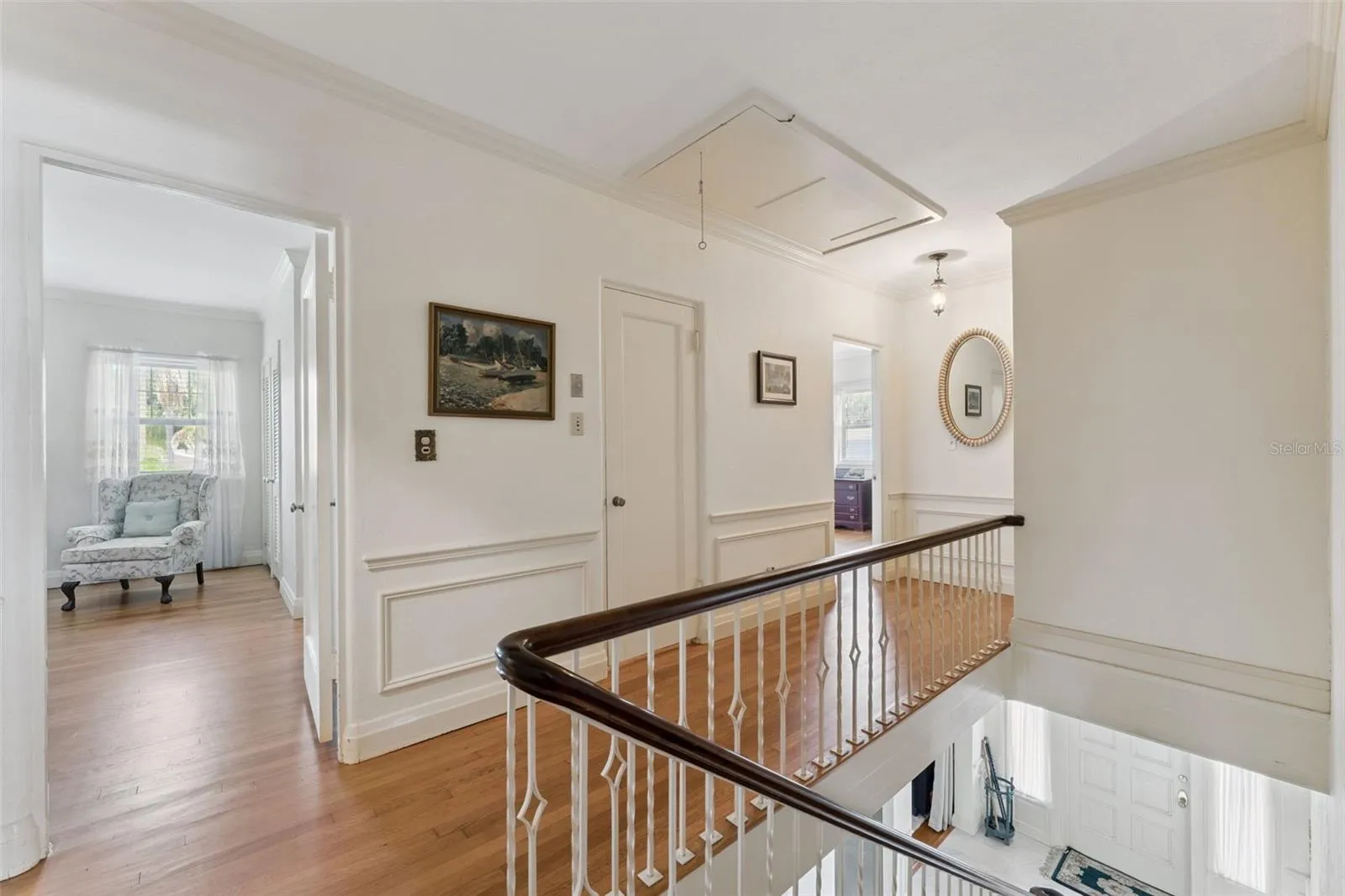 Upper-level landing with hardwood floors and access to multiple bedroom suites
