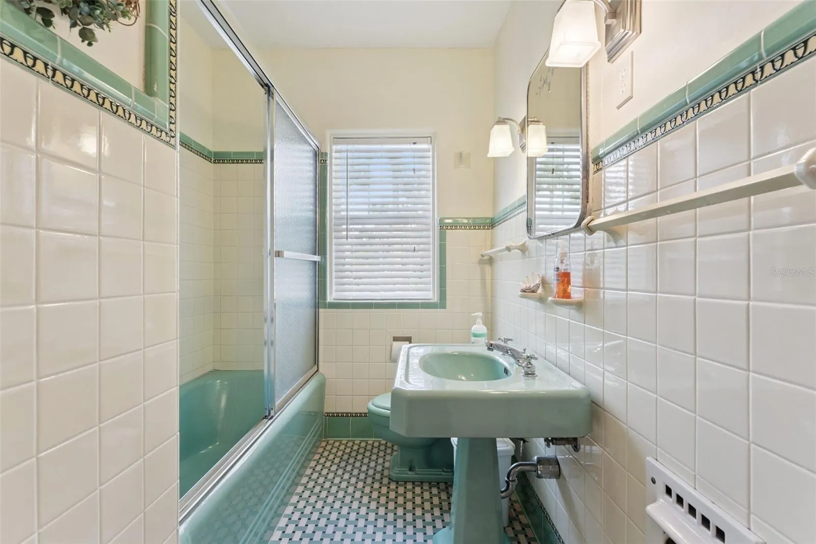 Charming vintage-style bath with decorative tile and wood vanity