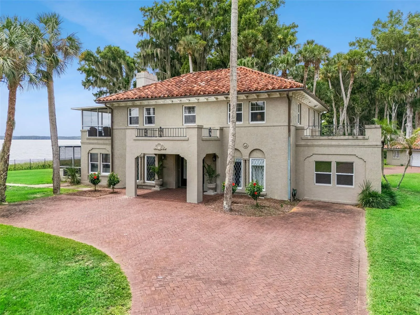 Timeless architecture surrounded by palms and mature landscaping on a generous waterfront lot