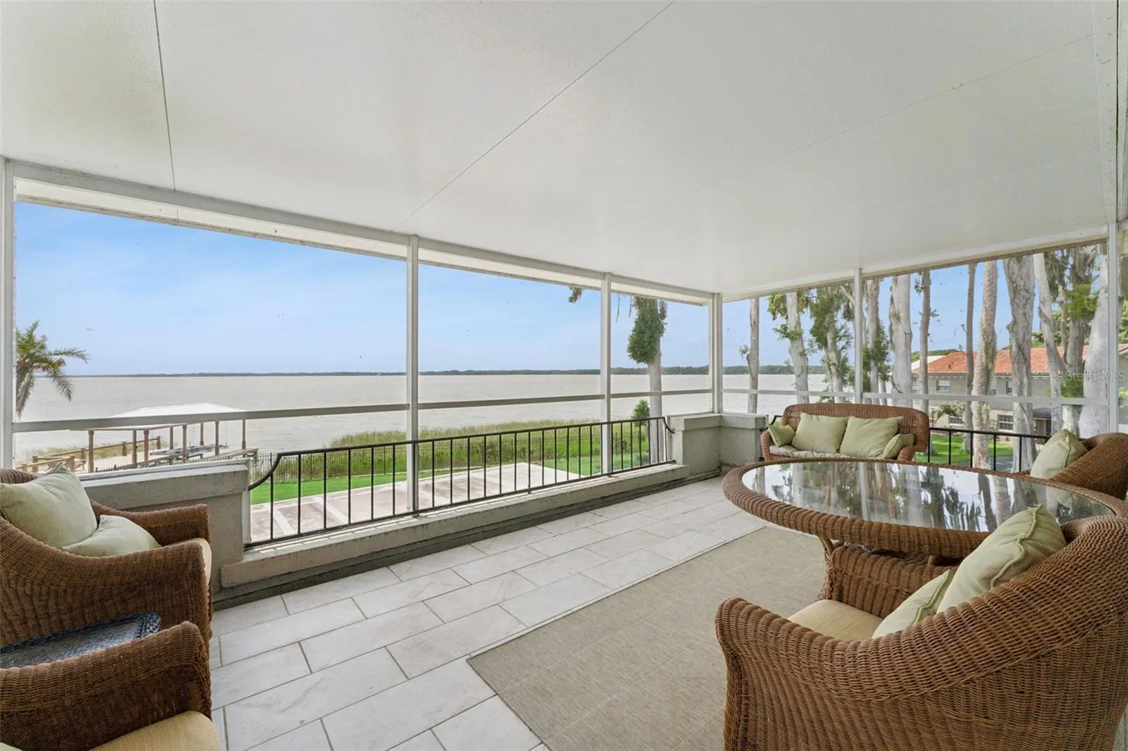 Upper screened balcony with rocking chairs and endless lake views
