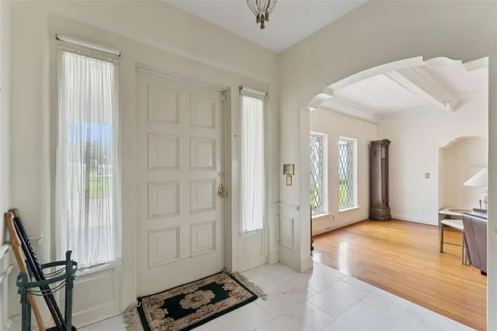 Welcoming marble-tiled foyer with sidelights and classic millwork