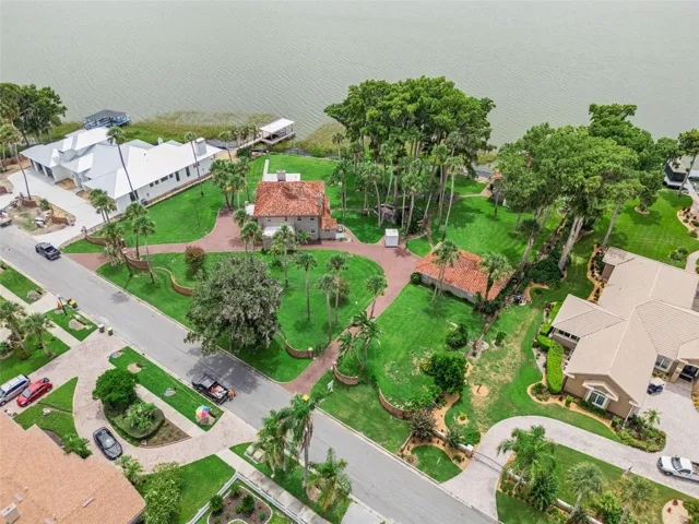 Drone view capturing the home, lush grounds, and Lake Harris waterfront