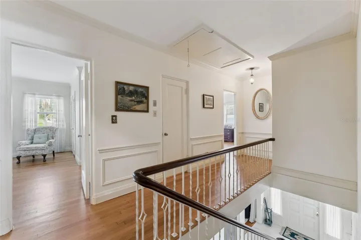 Upper-level landing with hardwood floors and access to multiple bedroom suites