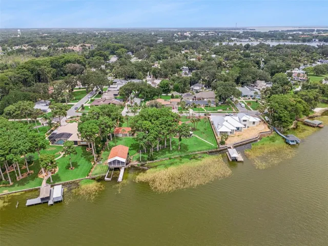 Rear aerial showcasing the private dock, grounds, and main residence