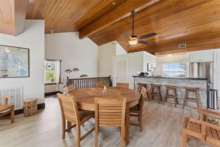 Breakfast bar and dining nook with warm wood tongue-and-groove ceiling
