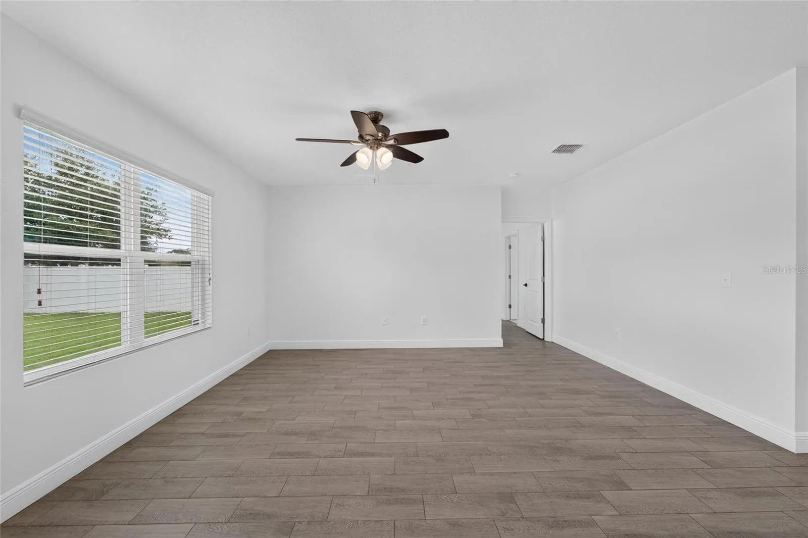 Living Room with large windows and hall to Primary Bedroom and Bath