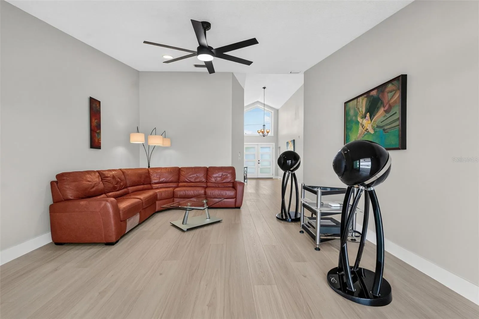 Formal living room with soaring vaulted ceilings and luxury vinyl plank flooring,  creating a grand and inviting space.