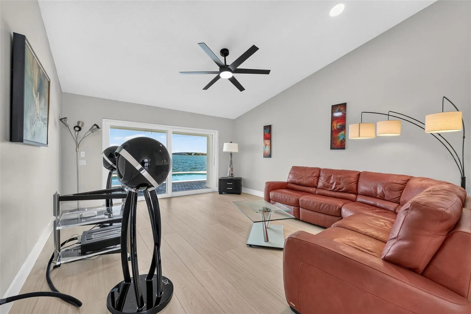 Elegant formal living room featuring sliding glass doors that frame serene water views and fill the space with natural light.