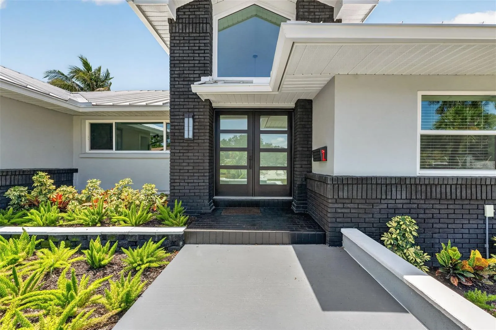 Modern double glass doors create a grand and inviting entry with a sleek, contemporary touch.