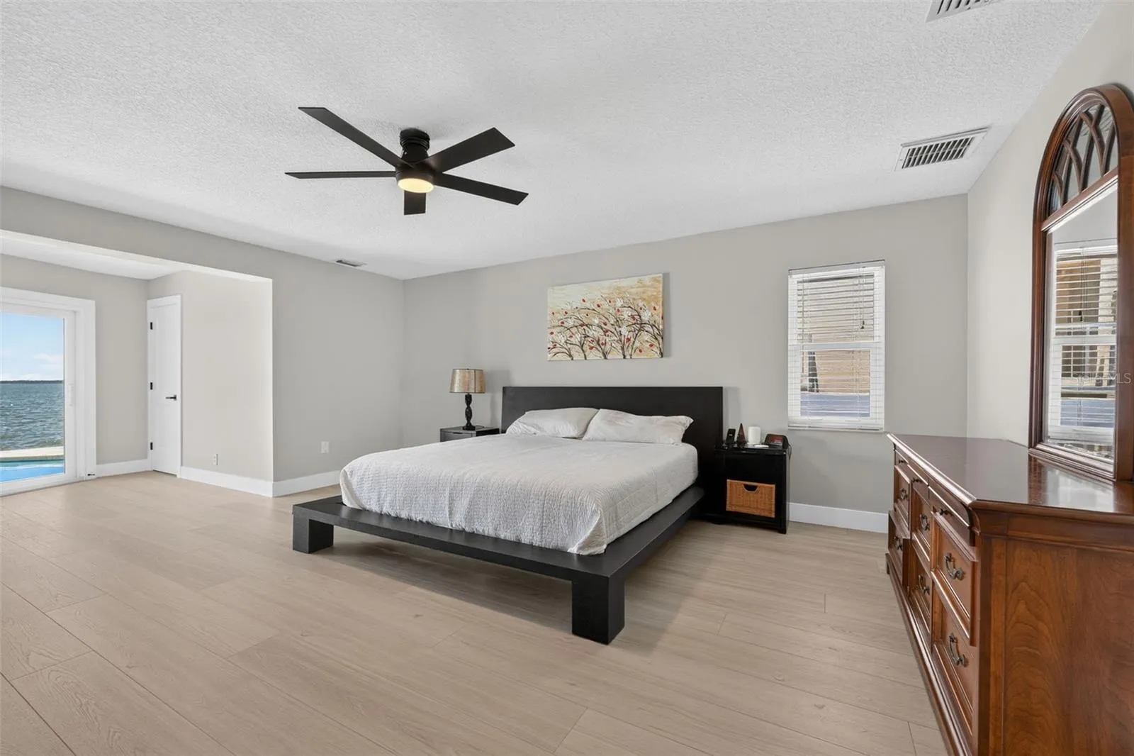 Spacious primary bedroom with new luxury vinyl plank flooring, offering plenty of room for all your furniture and personal touches.
