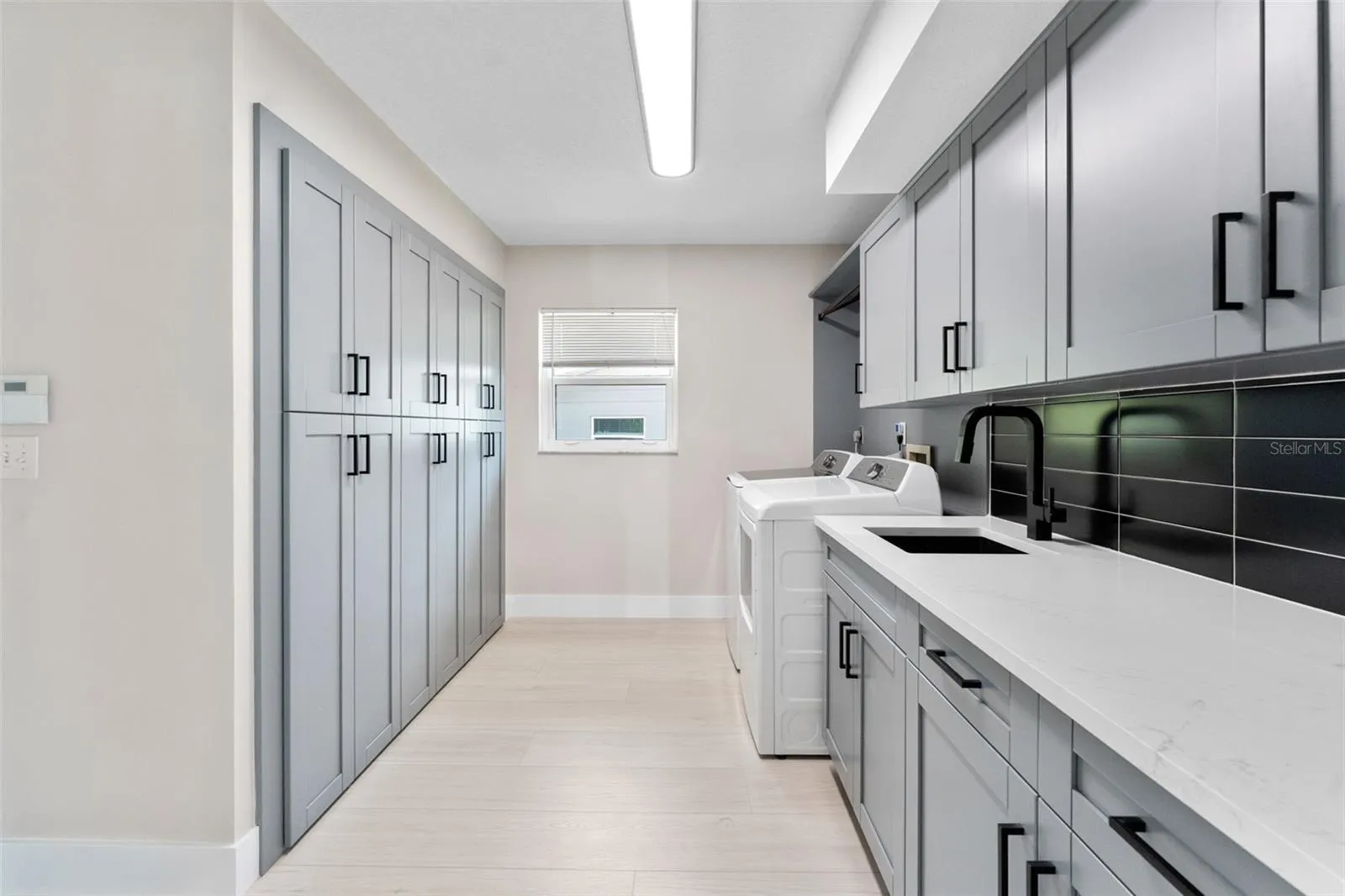 Laundry room with built-in cabinets for additional storage.