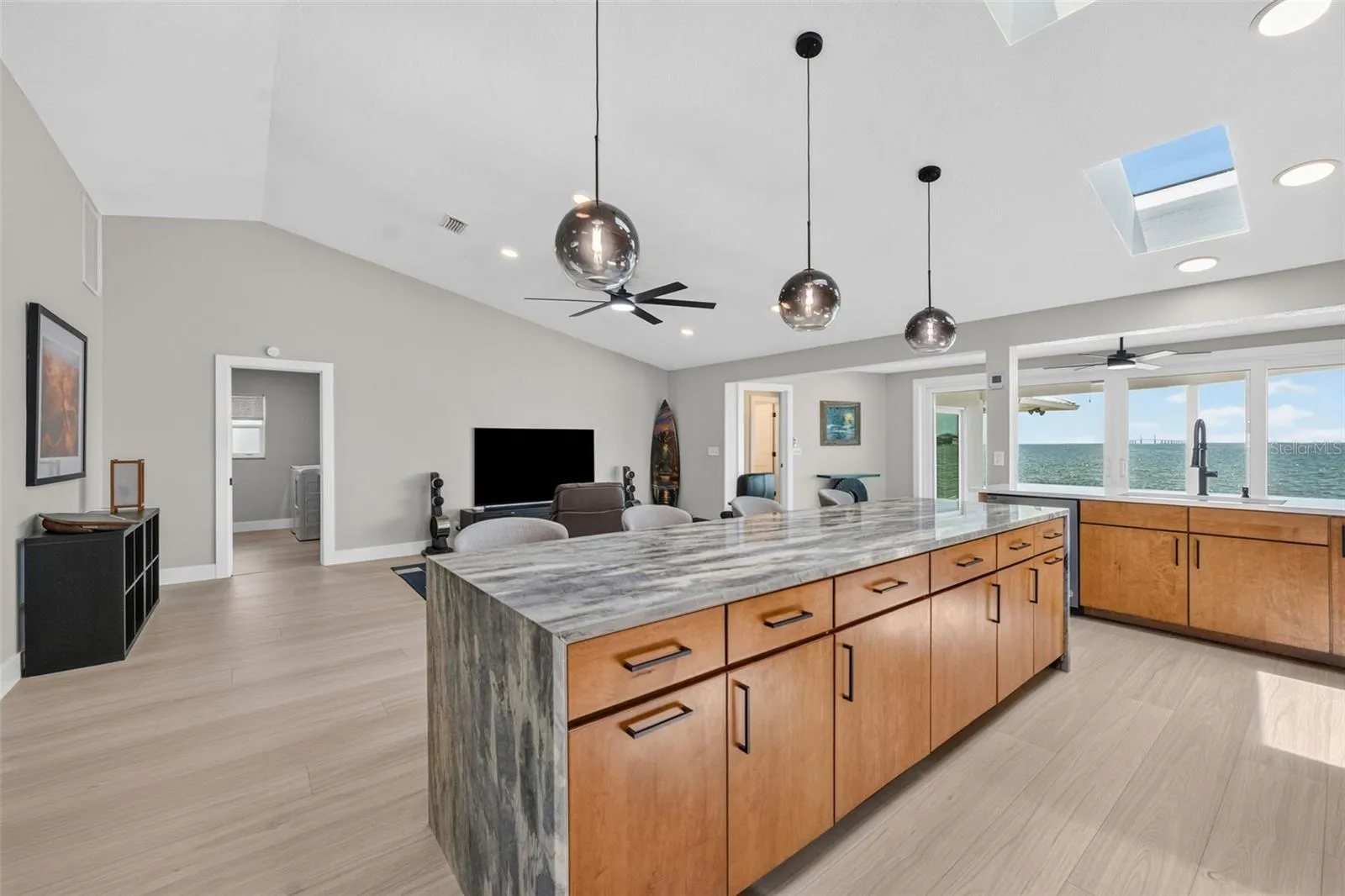 Expansive kitchen island featuring Level 5 granite with a dramatic waterfall edge
