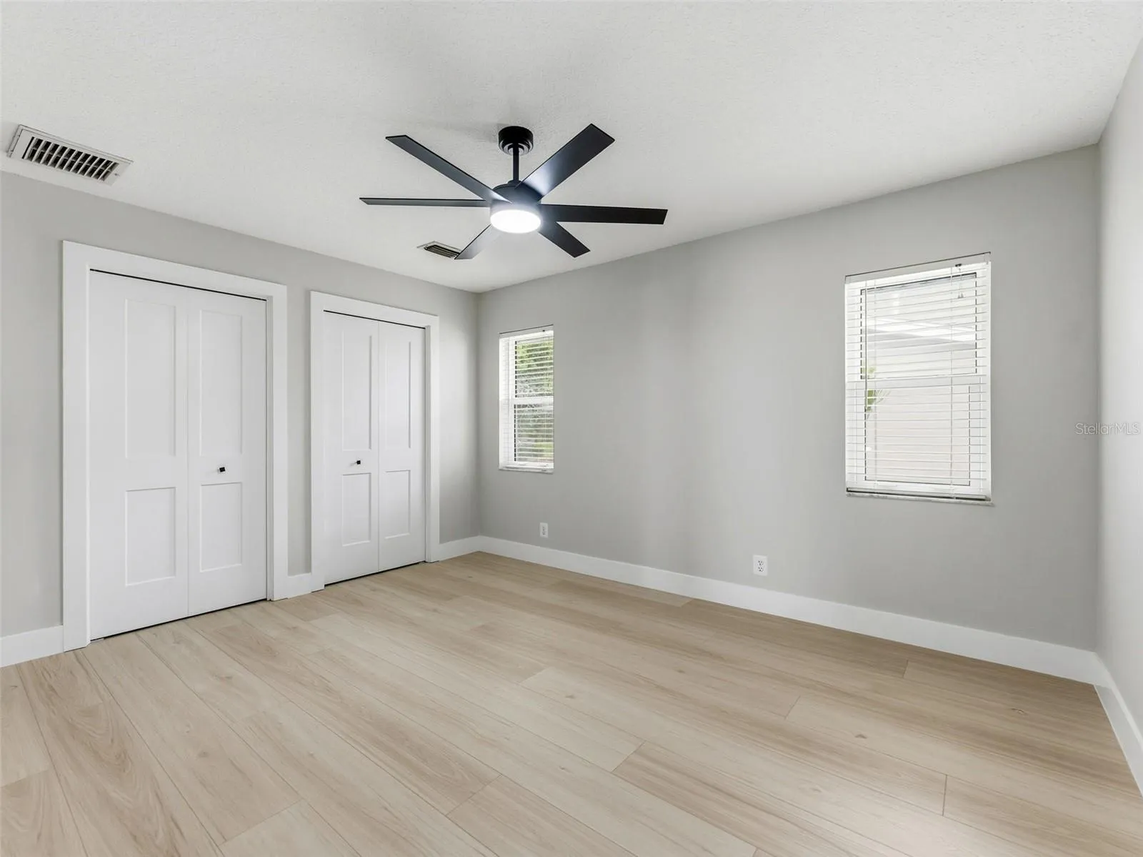 Bedroom 3 with luxury vinyl plank floors and a custom built-in closet, offering plenty of storage and comfort.