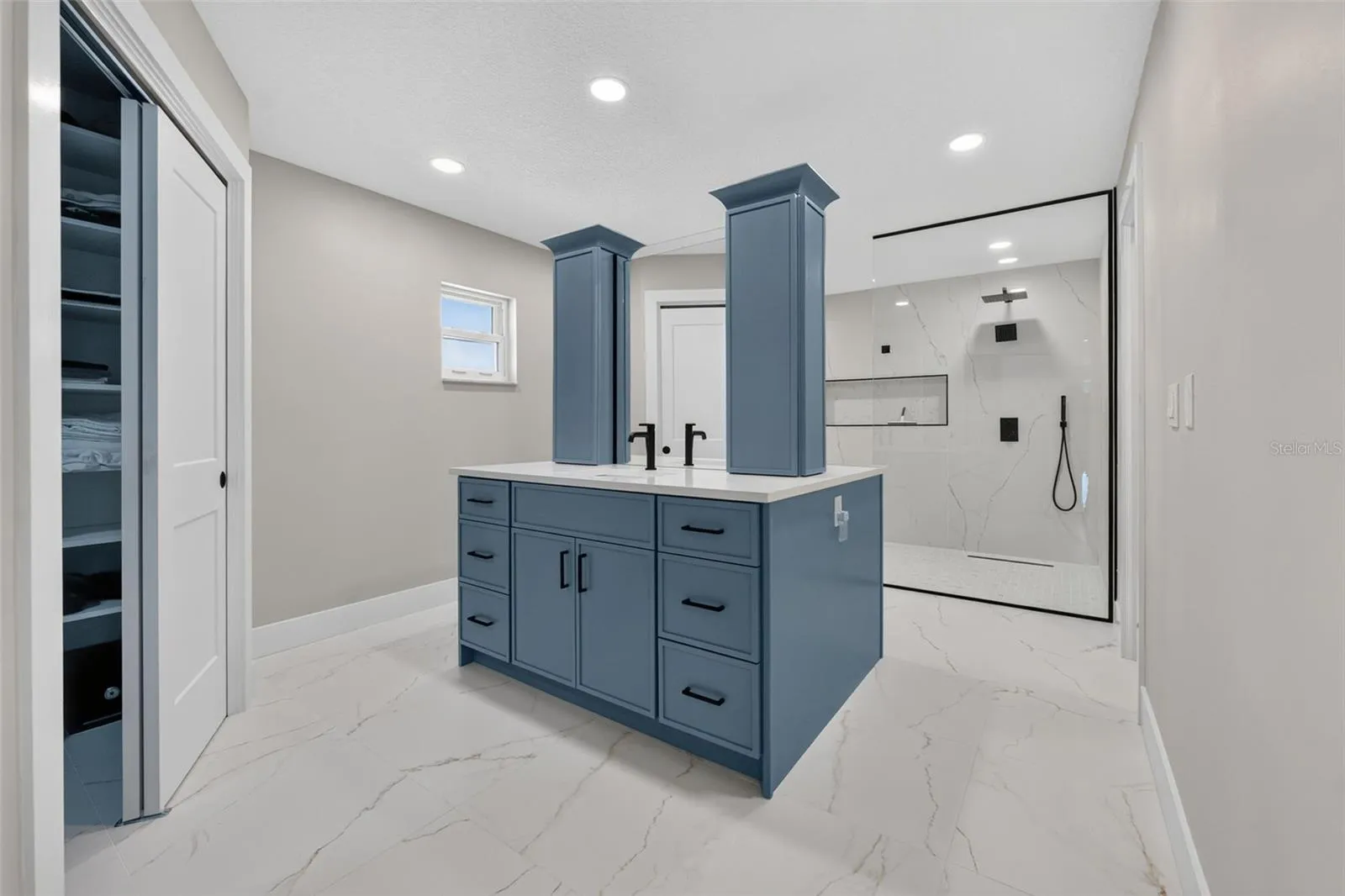 Stunning primary bath featuring custom blue dual vanities