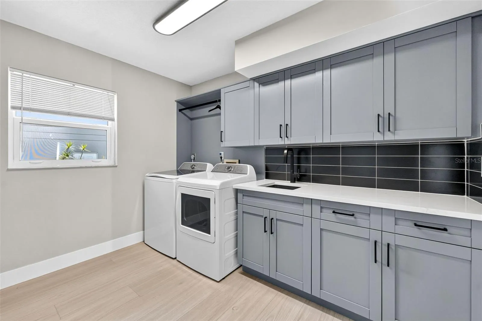Spacious new laundry suite with utility sink, washer and dryer, and abundant built-in storage