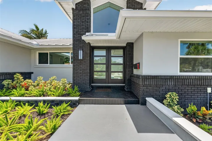 Modern double glass doors create a grand and inviting entry with a sleek, contemporary touch.