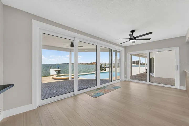Bright breakfast nook/bonus room with impact-rated sliding glass doors opens to the pool deck and stunning waterfront views.