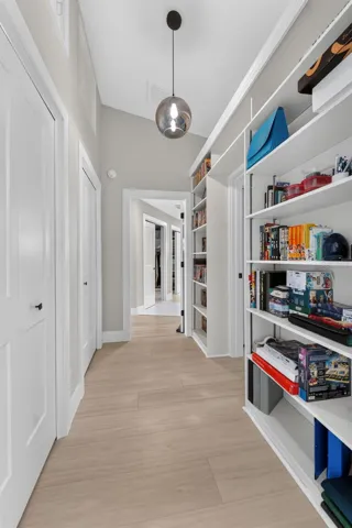 Hallway featuring built-in shelving and extra closet space, leading to Bedroom 2 and the luxurious primary suite