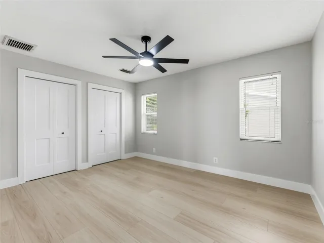 Bedroom 3 with luxury vinyl plank floors and a custom built-in closet, offering plenty of storage and comfort.