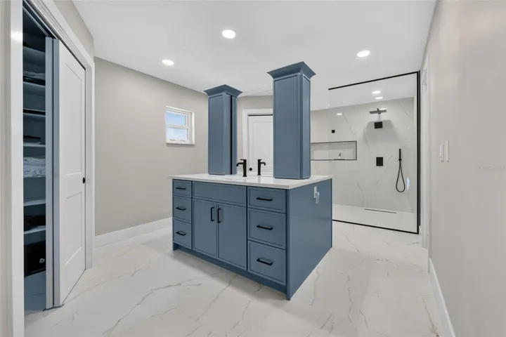 Stunning primary bath featuring custom blue dual vanities