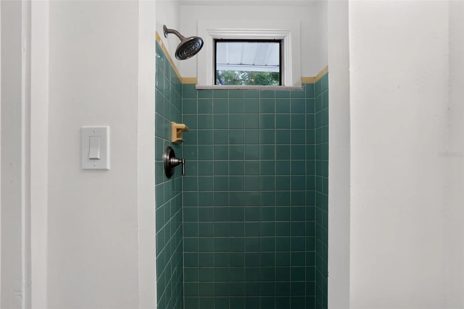 Green tile shower in the second bathroom of this 1922 bungalow