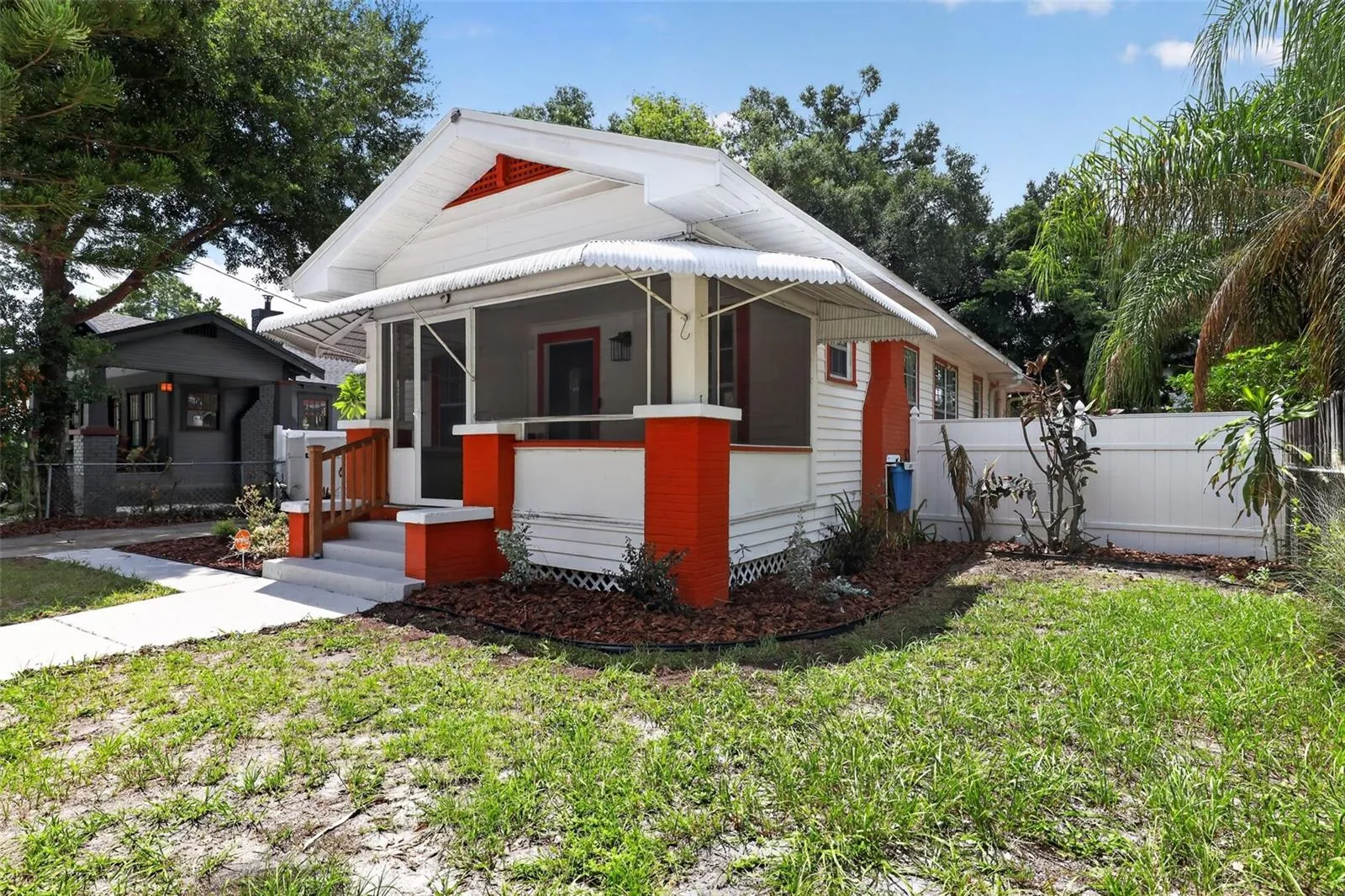 Charming front elevation of this classic 1922 bungalow with covered porch and distinctive red accents