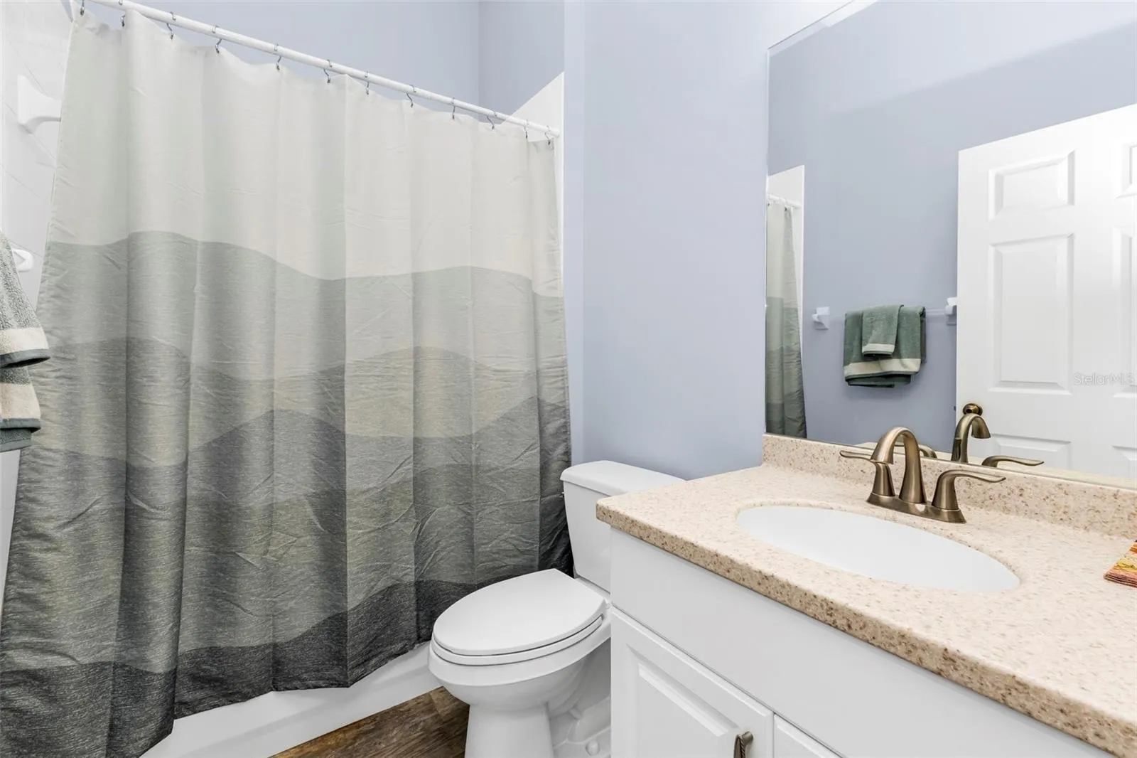 Guest bathroom with shower/tub combo and single vaniety.