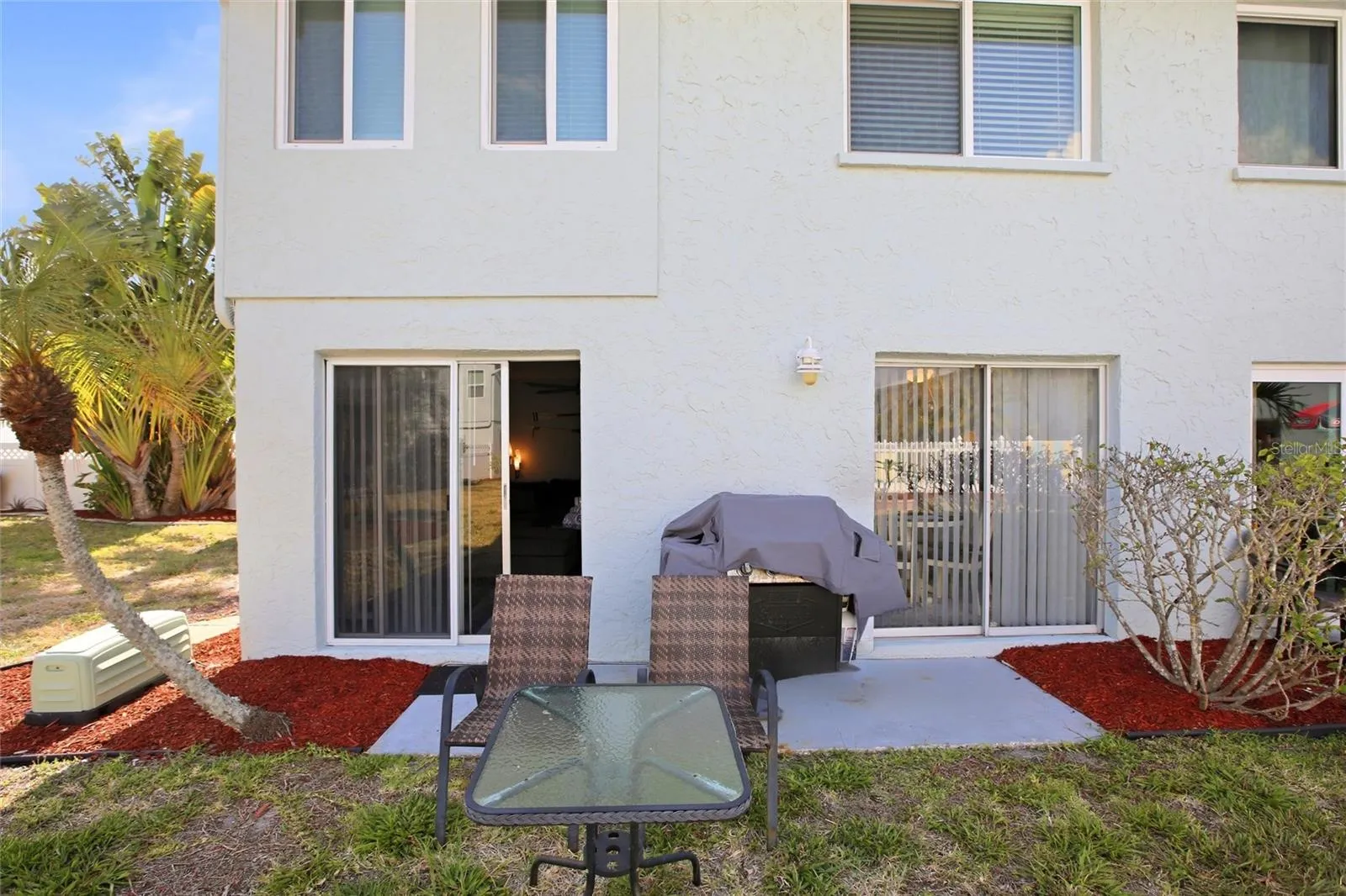 Exterior facing unit back two slider doors with patio