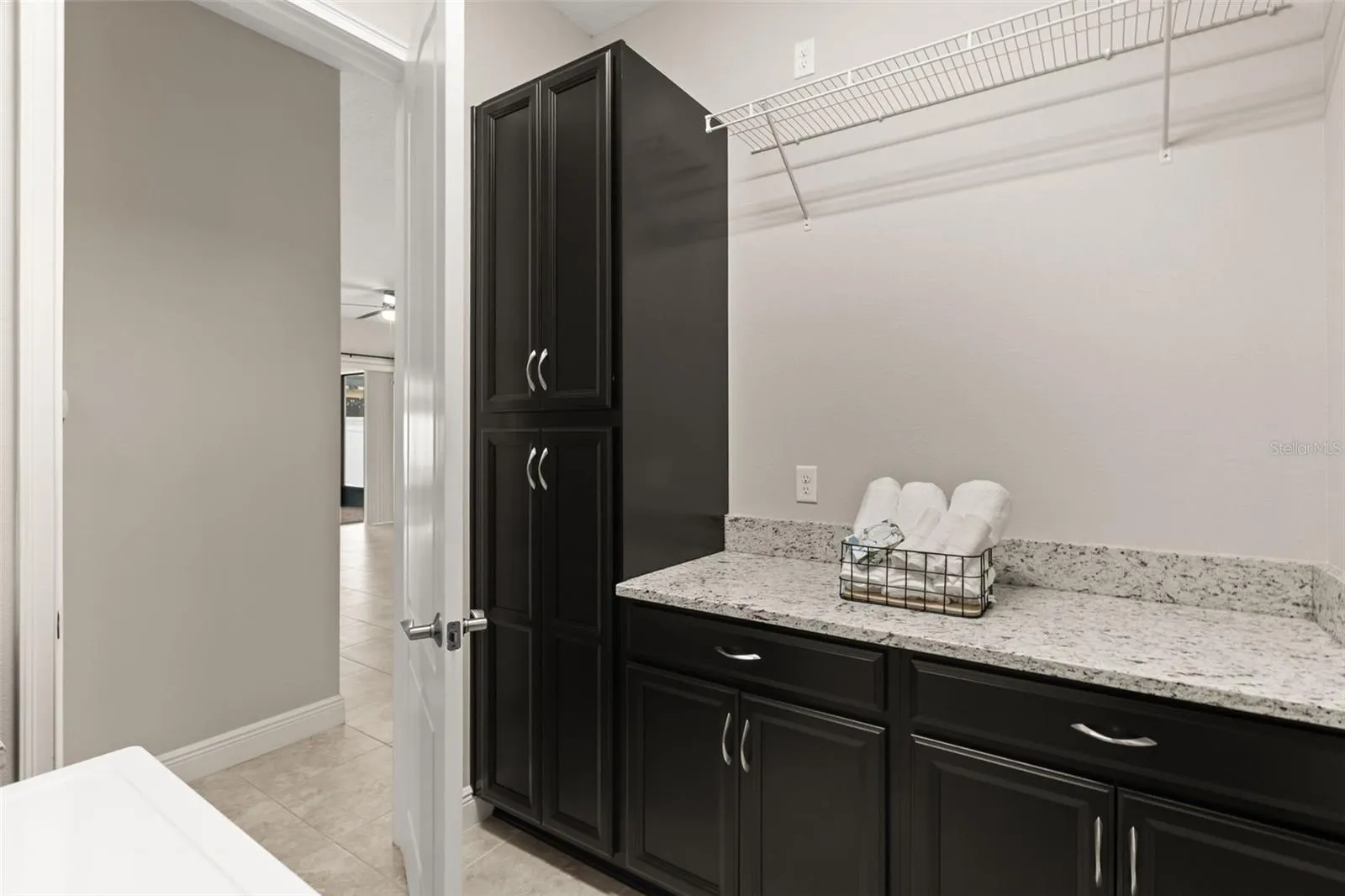 Plenty of counter space, cabinetry, and utility sink in laundry