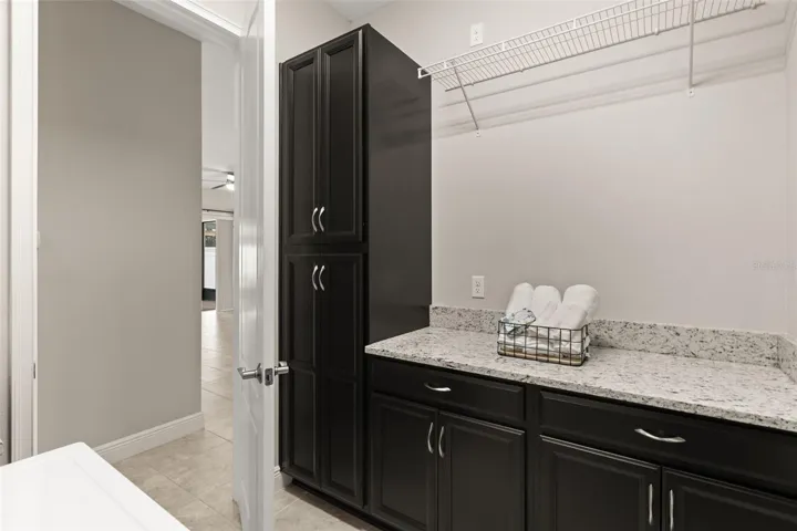Plenty of counter space, cabinetry, and utility sink in laundry