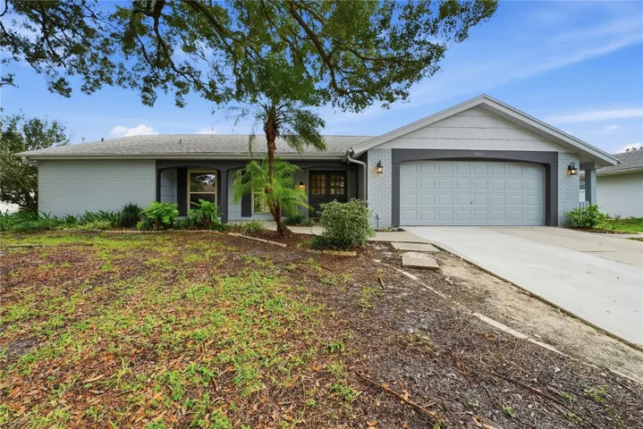 Freshly painted exterior with mature landscaping, an oversized two-car garage, and inviting covered entry.