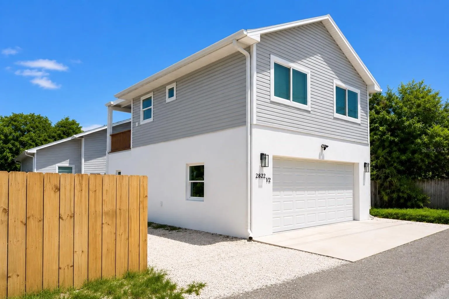 Exterior alley entrance of garage apartment: 2 tandem parking spaces on gravel.