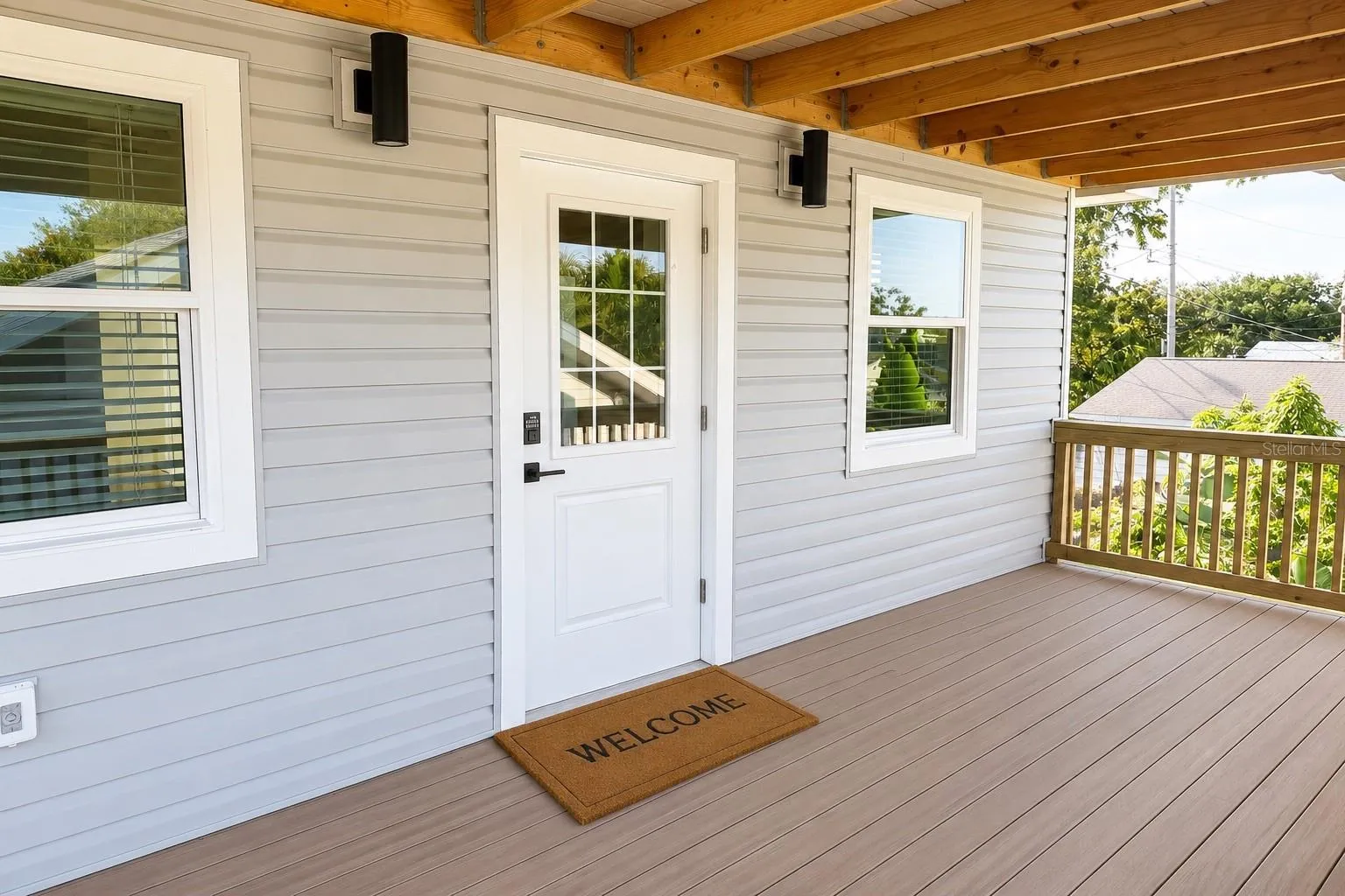 Welcoming front entry with a spacious composite deck, offering the perfect spot to relax and enjoy the outdoors before stepping inside.