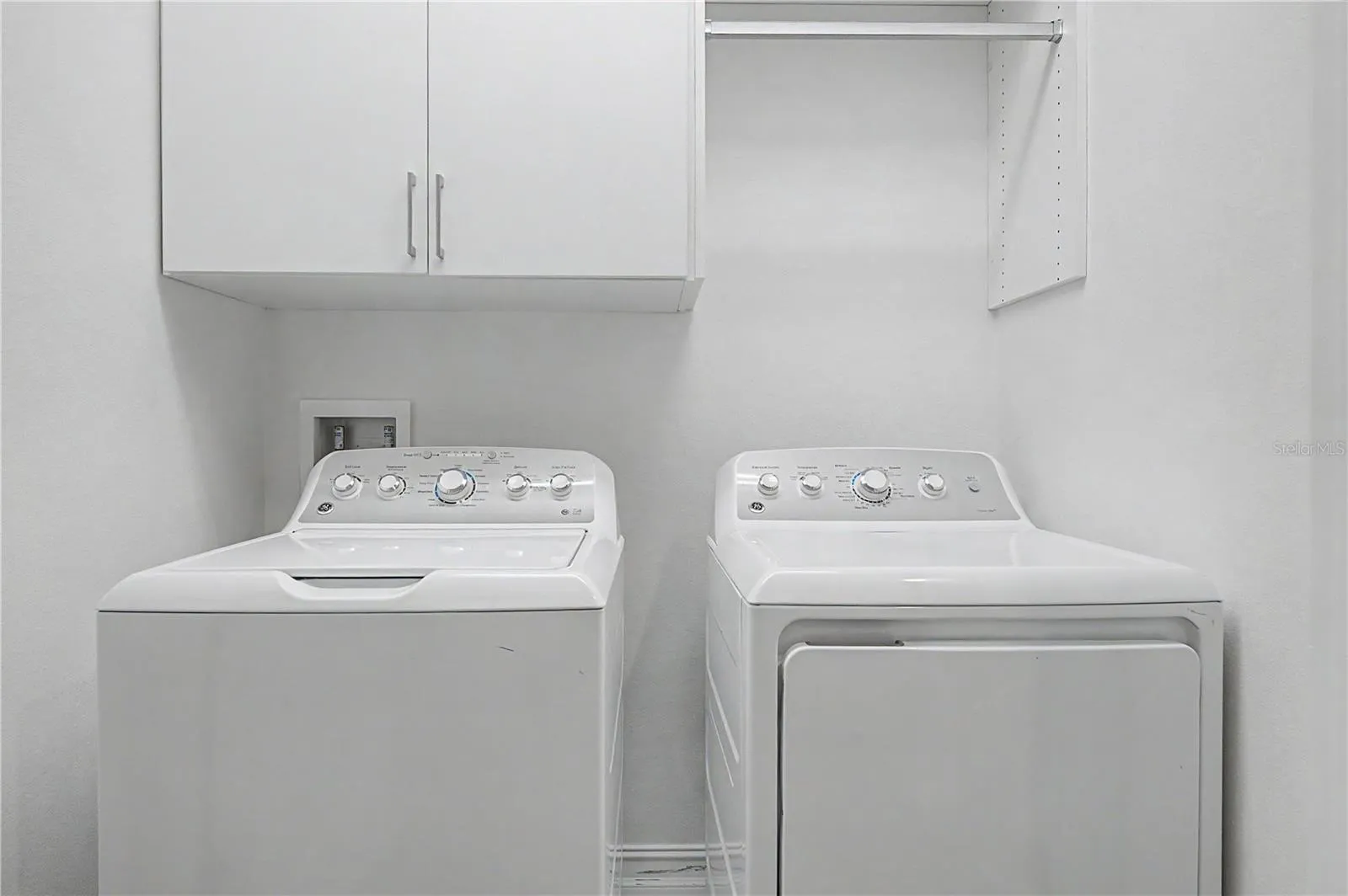 Third-level laundry room featuring high-efficiency washer and dryer connections with ample storage space.