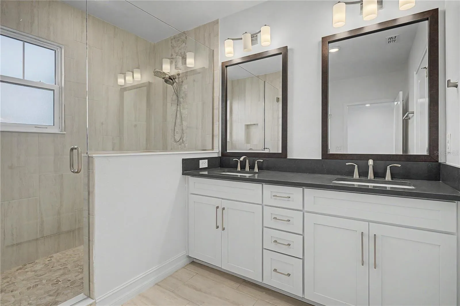 Third-level primary en-suite featuring double sinks and a spacious walk-in shower.