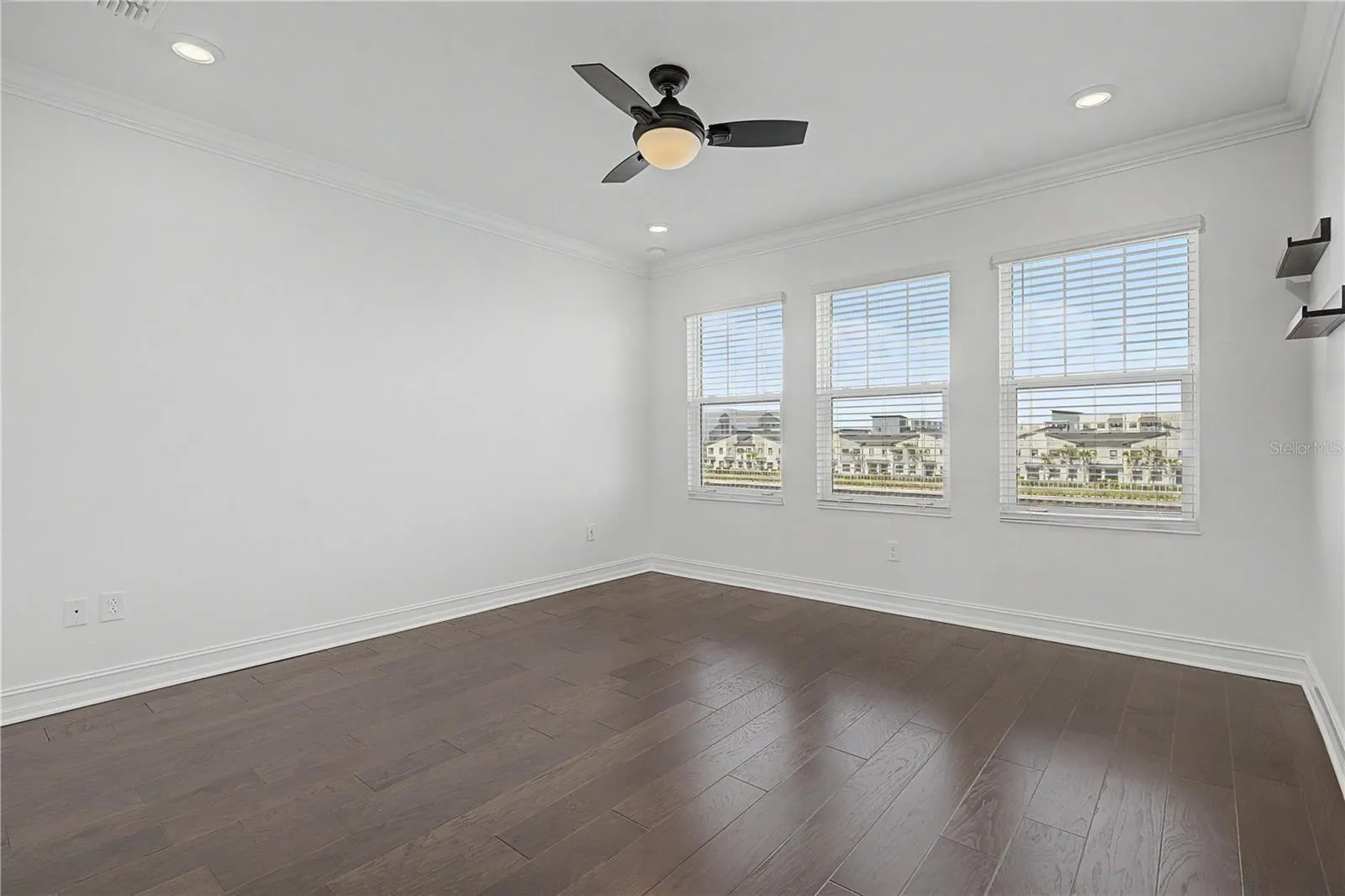 hird-level primary bedroom featuring a trio of west-facing windows that fill the space with natural light.
