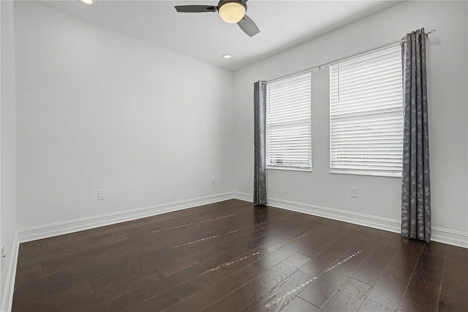 Third-level secondary bedroom offering a bright, comfortable space with abundant natural light from east-facing windows.