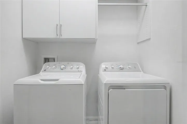 Third-level laundry room featuring high-efficiency washer and dryer connections with ample storage space.