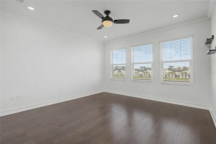 hird-level primary bedroom featuring a trio of west-facing windows that fill the space with natural light.