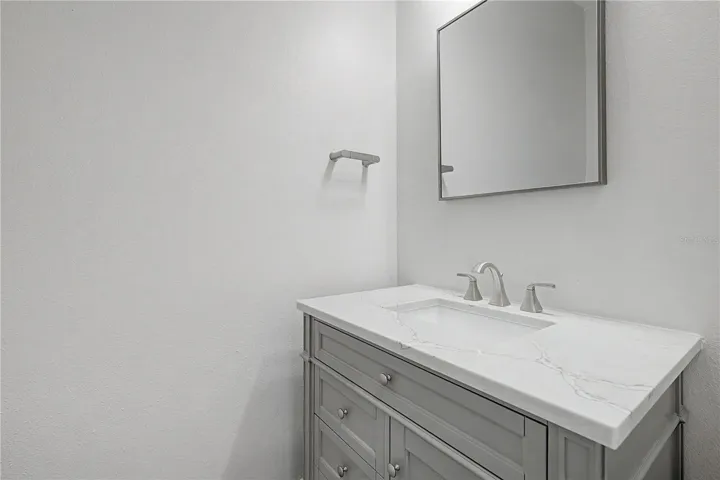 Second-level bathroom conveniently located in the hallway just off the living area, near the stairs leading to the third level.