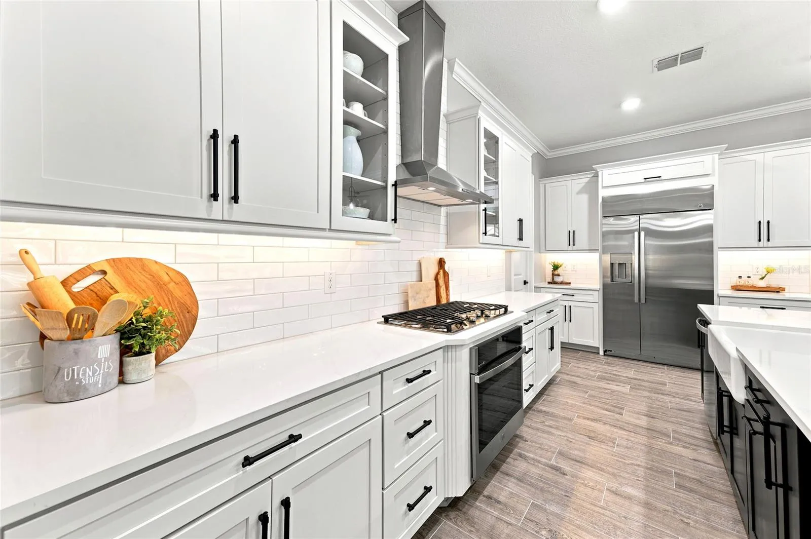 Whether preparing a casual meal or entertaining guests, the gas cooktop, expansive counter space, and abundant storage make this kitchen a chef's dream.