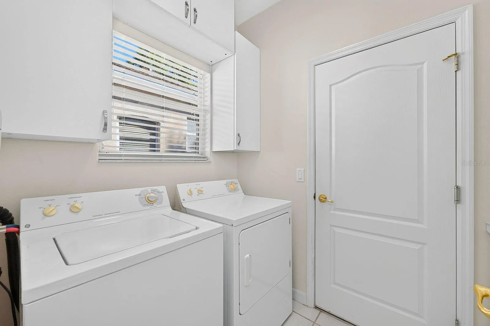 A Laundry Room just off the Kitchen, is complete with washer, dryer, storage cabinets and a folding table.