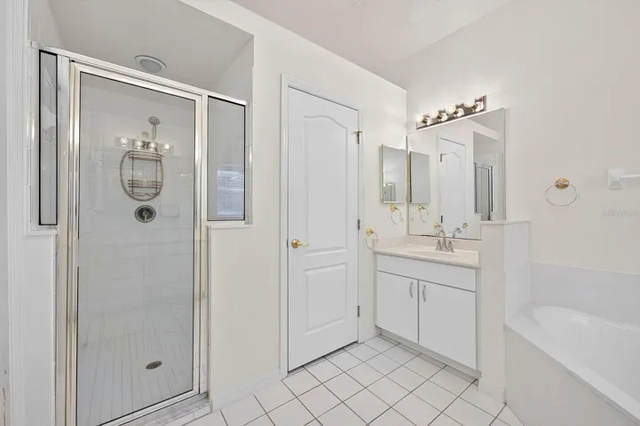 The PRIVATE EN SUITE BATH features dual vanities, a relaxing garden tub, a separate step-in shower with a NEWER LIGHT (2023), and a private water closet.