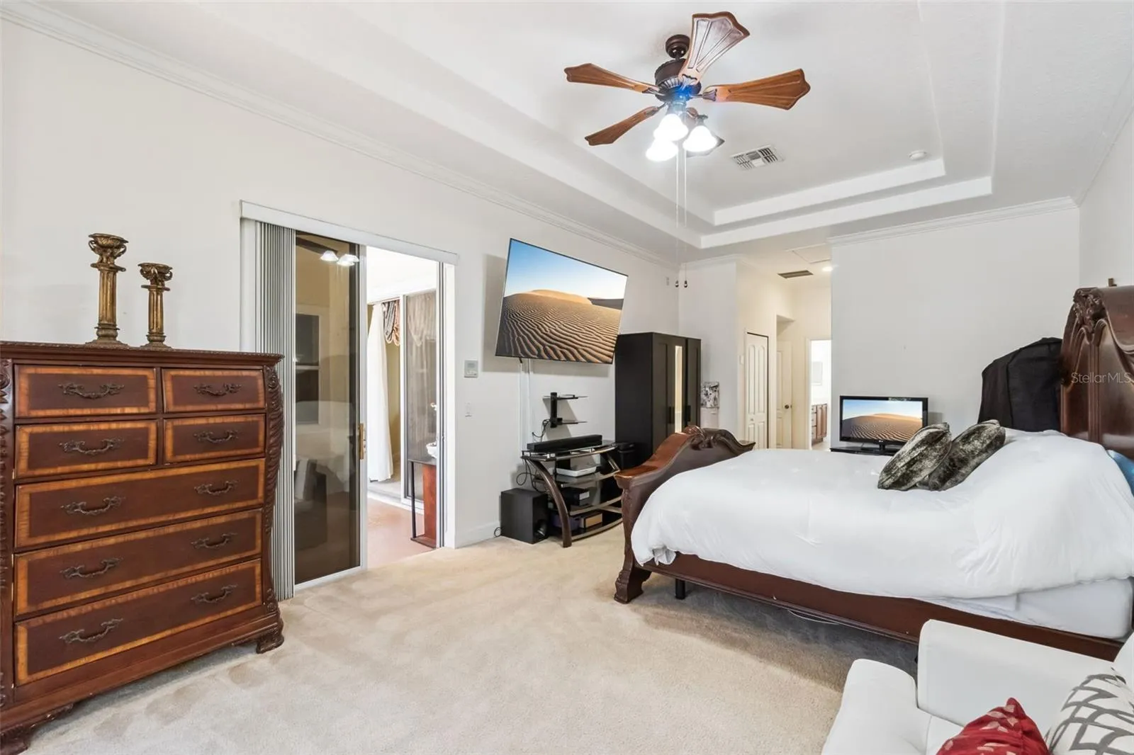 Primary suite with tray ceiling and barn door to the ensuite bathroom