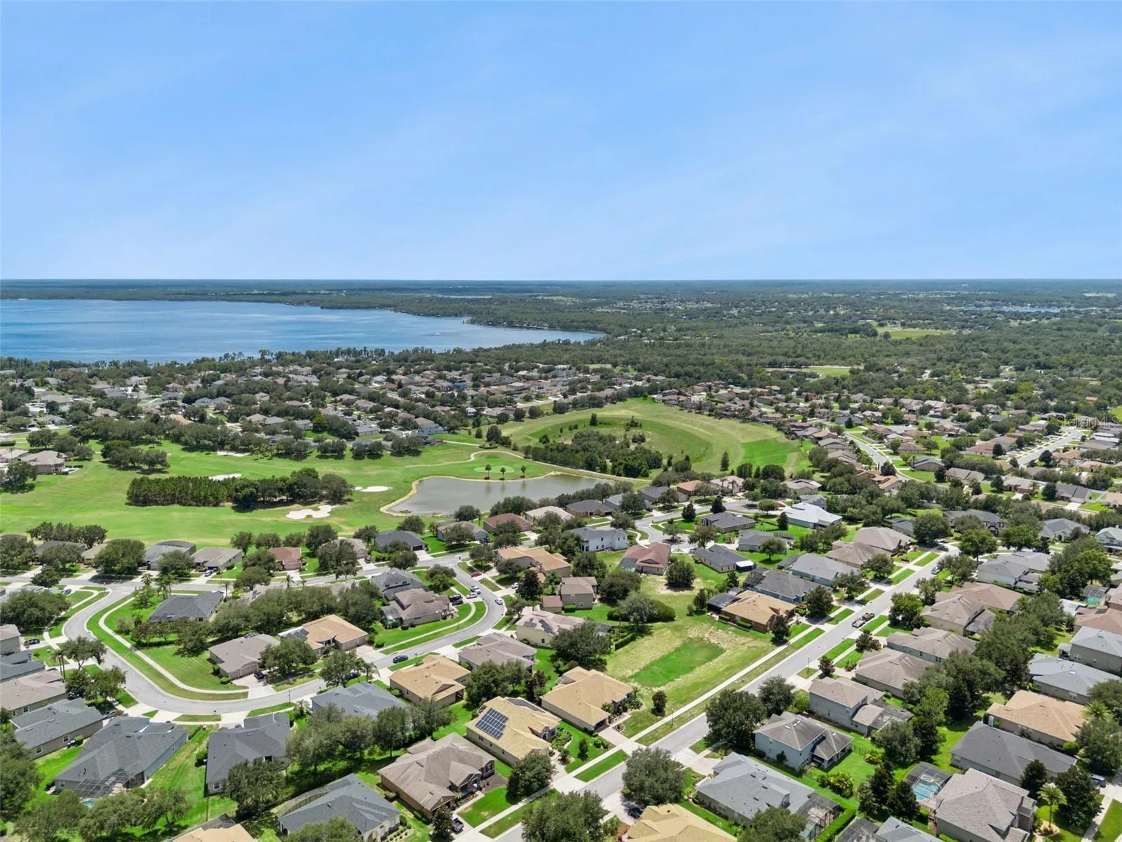 Aerial of the community with golf course and lake views